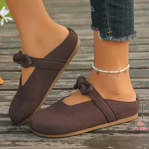 Detail view of brown Mary Jane mules showing 3cm thick sole and bow decoration