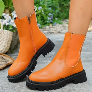 Bottines Martin orange vif à semelles épaisses avec fermeture éclair en plein air.