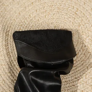 Primo piano di eleganti stivali slouchy in pelle nera con fodera in pelliccia sintetica
