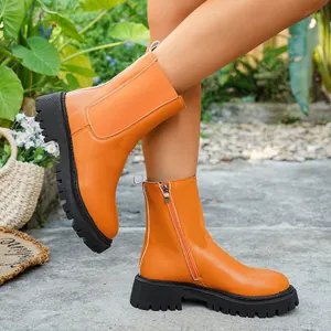 Vue détaillée de bottines à plateforme orange élégantes avec fermeture éclair.