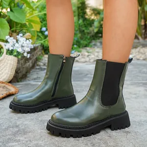 Gros plan de bottines à plateforme vert foncé pour femmes avec fermeture éclair latérale.