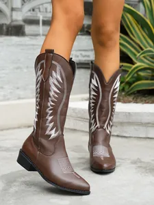 Close-up of stylish brown Western tall boots featuring intricate white embroidery detail