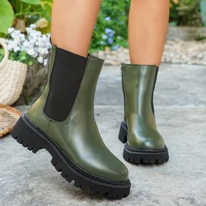 Détail rapproché de bottines Chelsea à plateforme vert olive dans un cadre extérieur