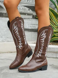 Detailed view of women's brown faux leather western cowboy boots with white embroidery