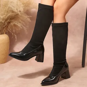 Detailed view of black patchwork boots with patent leather toe and chunky block heel