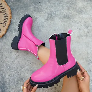 Vue détaillée des bottines Chelsea rose vif avec semelle crantée noire épaisse.