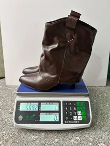 Détail du poids montrant une botte stiletto marron sur une balance électronique