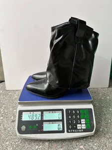 Vue détaillée d'une botte à talon aiguille noire pesée sur une balance numérique