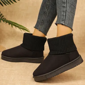 Stivali da neve neri con collo in maglia indossati con jeans per un look invernale