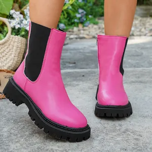 Gros plan de bottines Chelsea roses élégantes avec semelles crantées noires et fermeture éclair