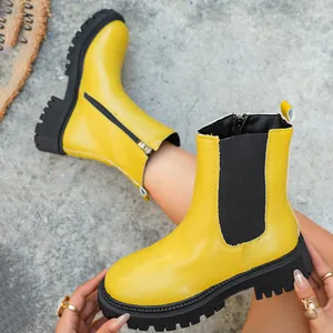 Gros plan de bottines jaunes à plateforme avec fermeture éclair et semelle noire robuste