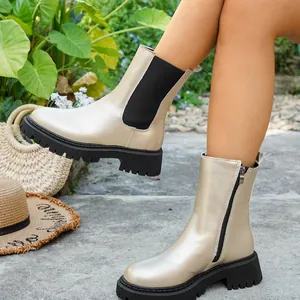 Bottines Chelsea à plateforme dorées avec fermeture éclair sur les jambes du modèle