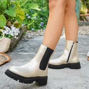 Gros plan de bottines blanches élégantes à bout rond avec une semelle compensée noire