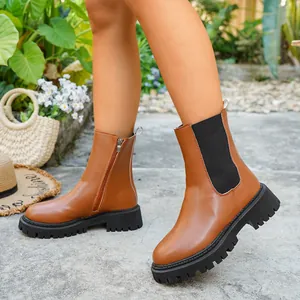 Gros plan sur des bottines en cuir marron avec semelles crantées et fermeture.