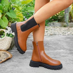 Détail de bottines à plateforme en cuir marron avec fermeture éclair et semelle épaisse