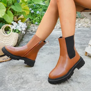 Bottines élégantes en cuir fauve avec semelle crantée épaisse et fermeture éclair dans un jardin