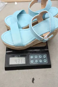 Vue détaillée de sandales compensées en daim bleu ciel pesant 431,1g sur une balance