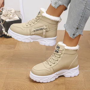 Gros plan de bottes de neige beige pour femmes avec doublure en fausse fourrure blanche.