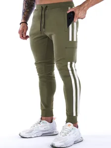 Detail view of men's olive green athletic joggers featuring side stripes and cargo pockets