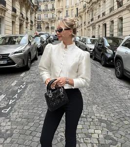 Detail view of a vintage puff sleeve blouse worn on a European street with ivory satin