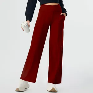 Detail of deep red high-waisted yoga pants with pockets and straight-leg design