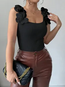 Dettaglio del top in maglia nera con eleganti fiori 3D sulle spalline sottili