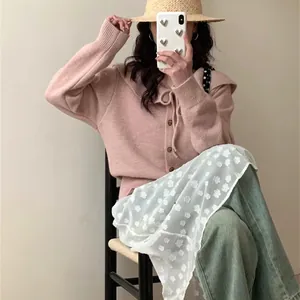 Close-up of pink knit cardigan with elegant doll collar and bow tie detail for women