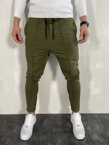 Dettaglio dei pantaloni sportivi slim fit verde oliva da uomo con caviglie a cerniera.