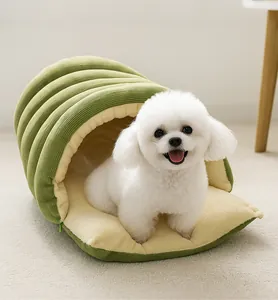 Close-up of a green corduroy pet tunnel bed with a white dog sitting comfortably inside