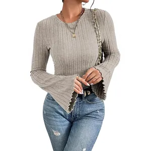 Detailed view of women's ribbed knit top featuring elegant flared bell sleeves and soft texture