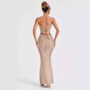 Vista trasera de un conjunto de punto beige con top de tubo con cordones y falda larga