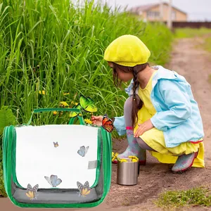 A young girl using the green portable transparent bird carrier in a lush outdoor field