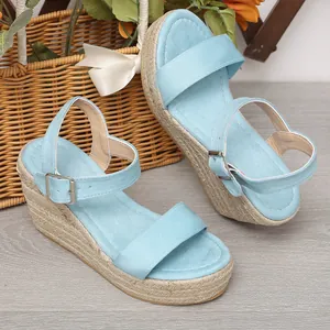 Sandales compensées en daim bleu avec semelle en corde, brides à boucles et bout ouvert.