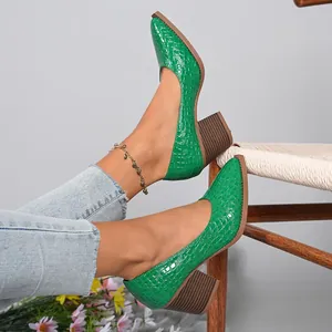 Detailed view of vibrant green crocodile patterned pumps with chunky block heels