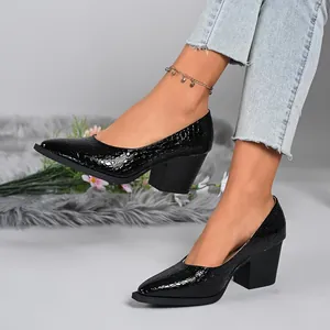 Detailed macro view of black crocodile-textured pointed-toe chunky heel pumps on a model