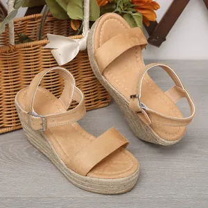 Vue détaillée des sandales compensées en daim camel avec semelle en jute tressé.