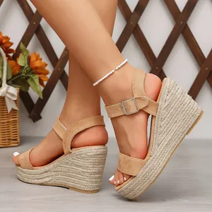 Sandales compensées beiges élégantes avec semelle en corde tressée et bride cheville.