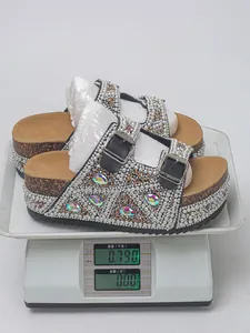 Detailed view of pearl rhinestone platform sandals on a scale showing product weight