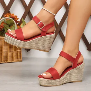 Sandales à talons compensés en daim rouge avec semelle en jute tressée et bride.