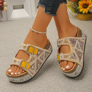 Close-up of yellow platform sandals decorated with pearls and colorful rhinestones.