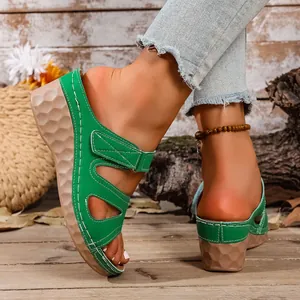 Primer plano de elegantes sandalias de cuña verdes con suela de plataforma texturizada