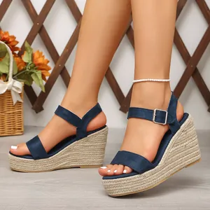 Gros plan sur des sandales compensées bleu marine avec talons en corde tressée et bride.