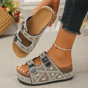 Detailed view of women's platform slides with pearls, rhinestones, and cork sole