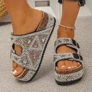 Detailed shot of sparkling rhinestone platform sandals with pearl decor on foot