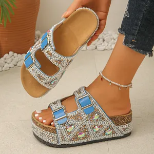 Detailed view of women's platform slides decorated with pearls and colorful crystals.