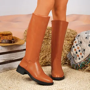 Braune Damen-Lederstiefel im britischen Stil, kniehoch, in rustikaler Stroh-Umgebung