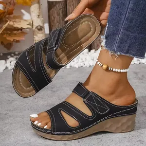 Detalle de las elegantes sandalias de cuña con plataforma negras para mujer costuras