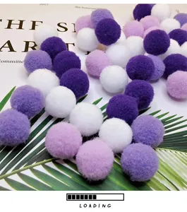 Close-up detail of soft purple and white plush cat toy balls on leaf background