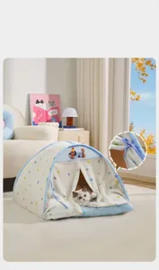 Detail view of enclosed polka dot cat tent bed featuring adjustable blue tie-back curtains