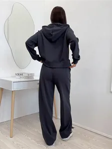 Back view of a minimalist black hooded cotton tracksuit set showing relaxed fit and style